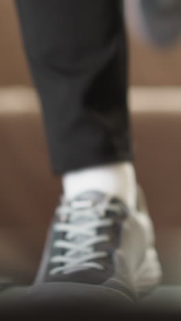 sportswoman engages in treadmill session. dynamic woman in sports shoes practice jogging on gym equipment closeup. energetic woman keeps fit at home