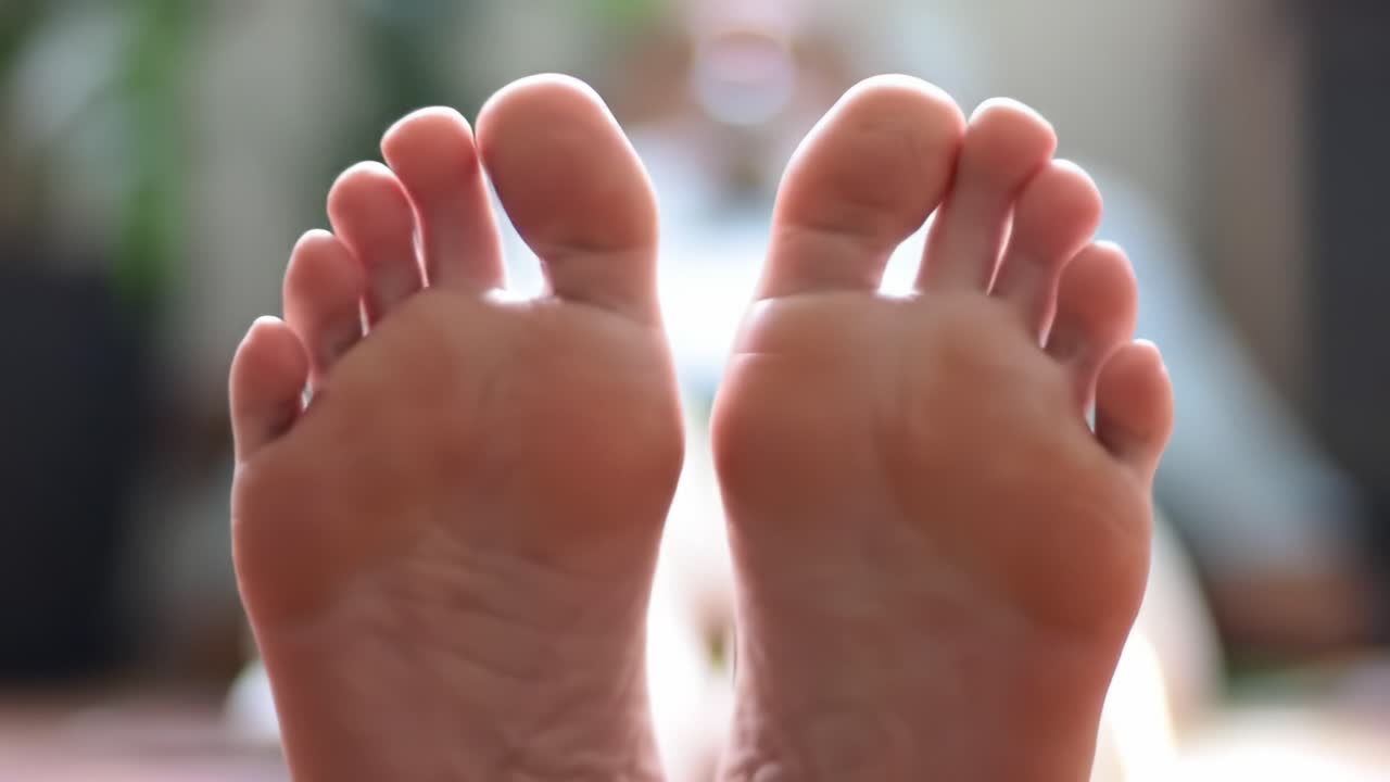 Close-Up of Human Feet Showing Detailed Toes and Soles in a Relaxed Setting, Highlighting Comfort and Serenity in the Indoor Environment
