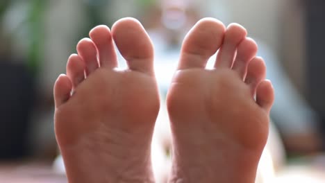 close-up of human feet showing detailed toes and soles in a relaxed setting, highlighting comfort and serenity in the indoor environment