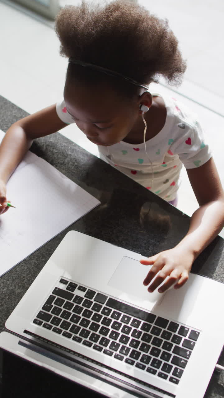 video vertical de una chica afroamericana usando una computadora portátil