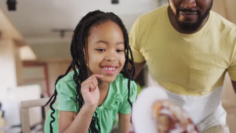 Happy-african-american-father-and-daughter-doing-science-experiments-with-artificial-volcano