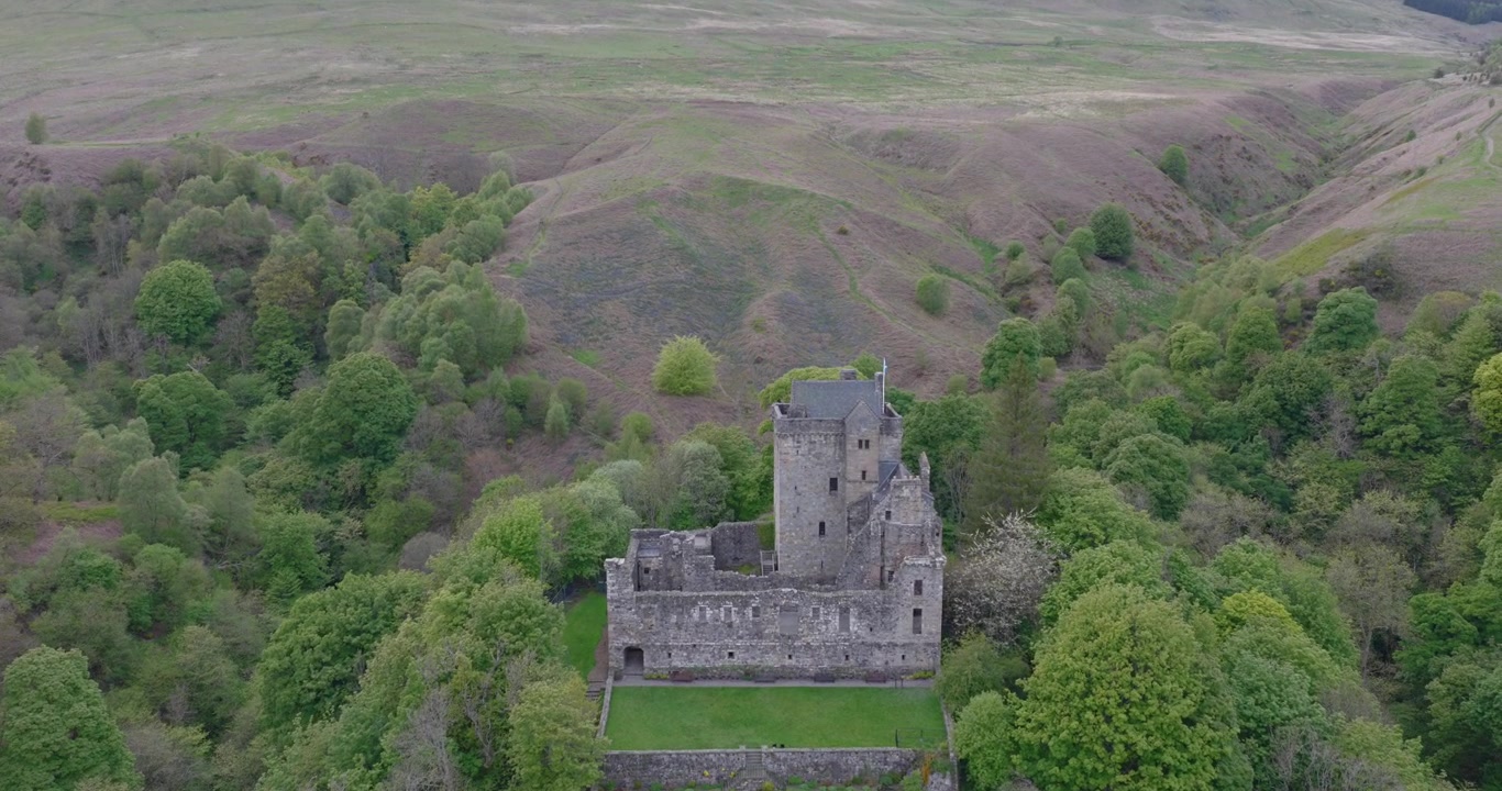 Riprese aeree cinematografiche con drone del Castello Campbell, un castello storico immerso nelle Ochil Hills sopra il villaggio di Dollar nella Scozia centrale. Sorvolo che mostra il castello circondato da una fitta boscaglia.