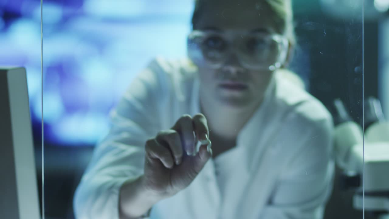 una mujer científica está usando interfaces futuristas en vidrio.