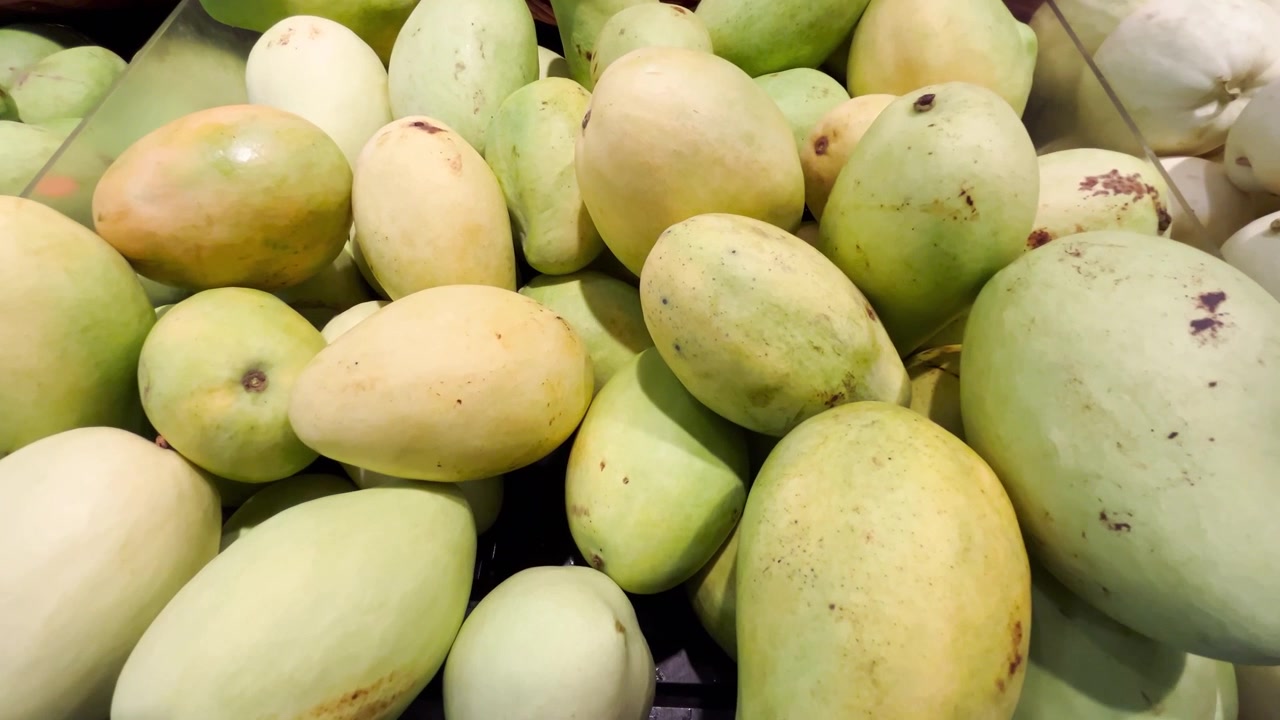 Świeże, dojrzałe mango wyłożone w sklepie spożywczym.