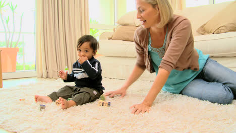 Madre-Joven-Jugando-Con-Su-Bebé-En-La-Alfombra