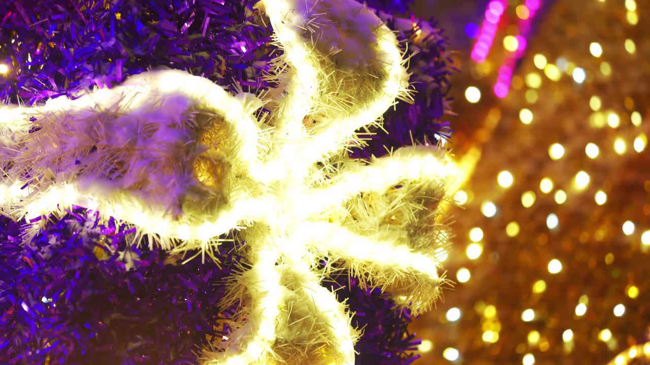 colorida y brillante decoración navideña. decoración reluciente de neón brillante en la calle de cerca. feliz año nuevo. celebración de las vacaciones de invierno en la ciudad nocturna. imágenes en 4k