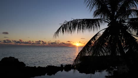 Tiro-Largo-De-Puesta-De-Sol-Y-Cielo-Nocturno-Sobre-La-Laguna-De-Fakarava,-Polinesia-Francesa,-Océano-Pacífico-Sur-Con-Reflexiones-Sobre-La-Superficie-Del-Agua-Tranquila