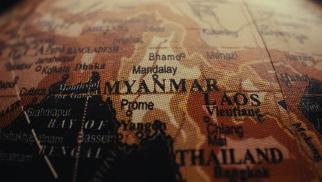 close-up of a world globe focusing on myanmar, laos and thailand