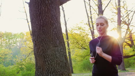 an attractive young woman makes a morning jog in the forest the sun is shining beautifully and gives