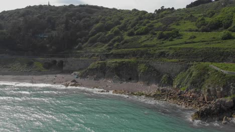 wide panoramic drone shot of grass mountain by the sea