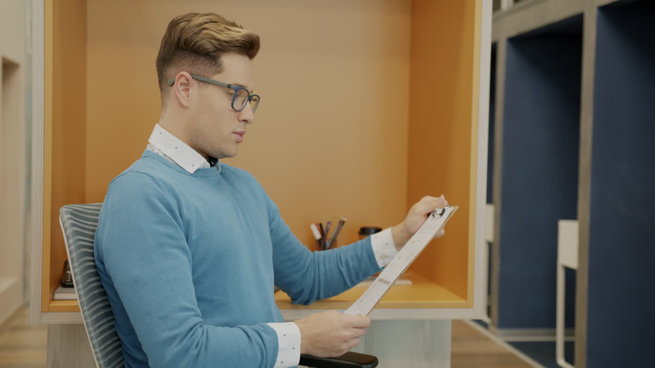 Man in office holding clipboard