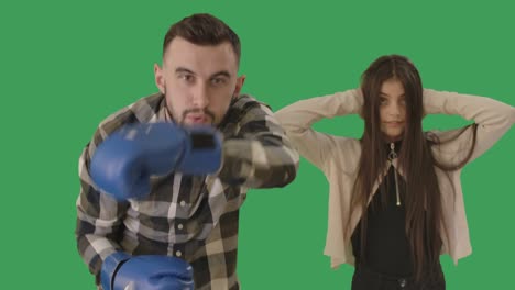 confident young caucasian father boxing camera as shocked teenage daughter holding head with hands at the background. handsome man defending honor of girl. chromakey, greenscreen. cinema 4k prores hq.