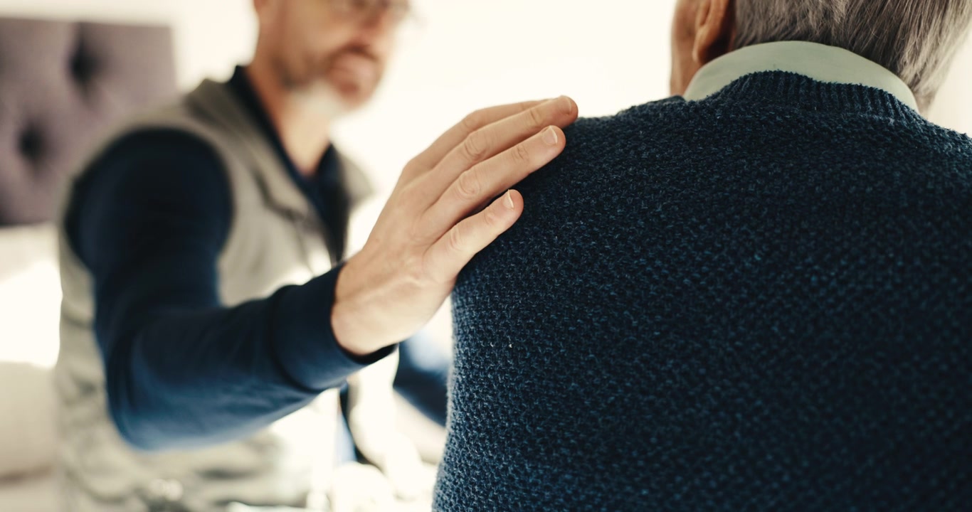 Uomo che conforta un anziano con una mano sulla spalla