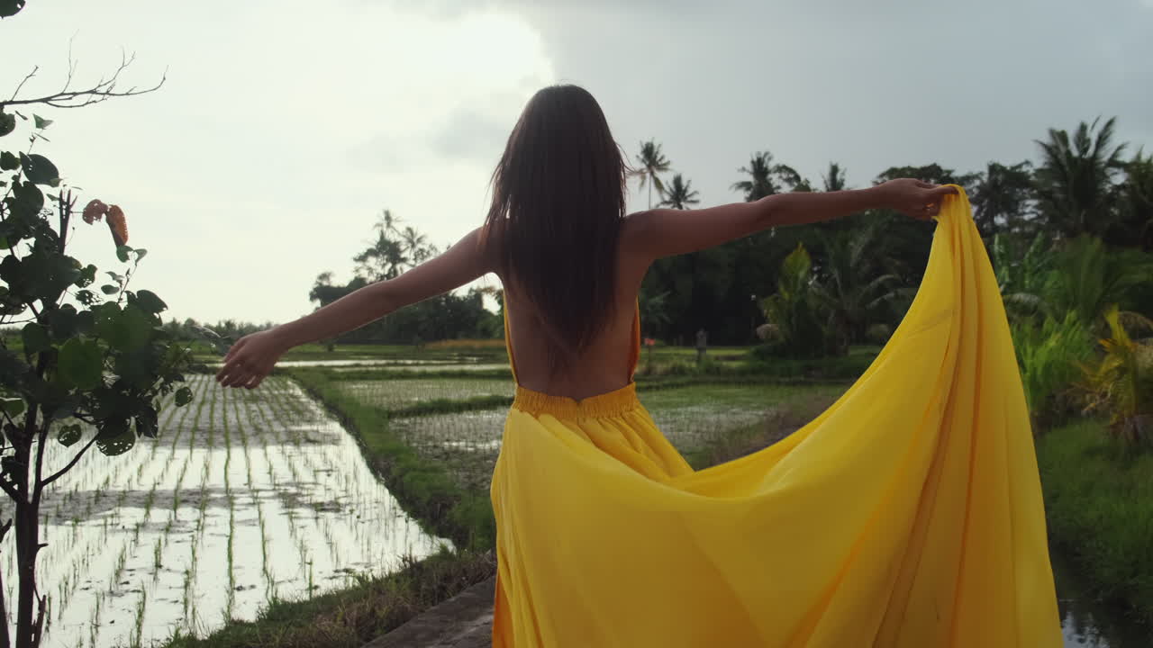 женщина в желтом платье на рисовом поле.