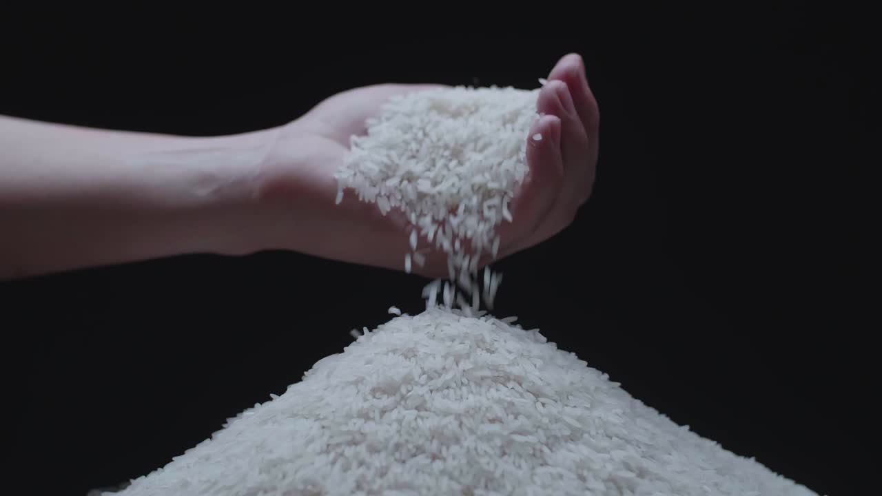 Rice Grains Falling From Hand In Slow Motion  Over The Rice Guard