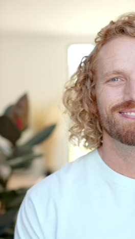 Vertical video of portrait of happy caucasian man at home in slow motion