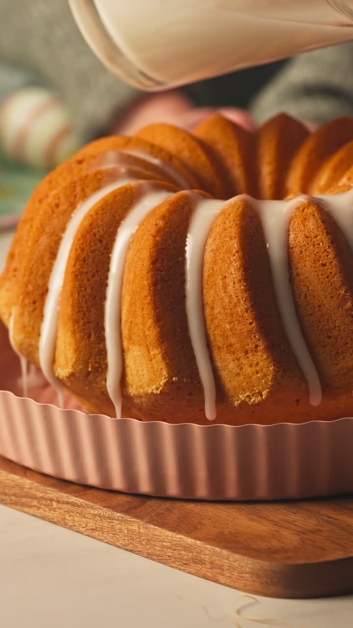 Close-up vertical of an Easter bundt cake topped with icing on a wooden board