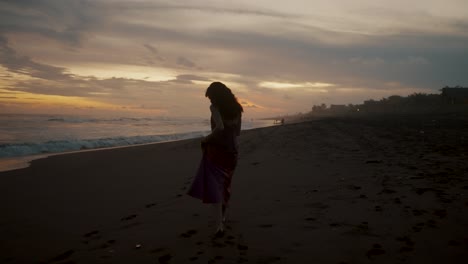 lone female tourist walking at beach during dusk