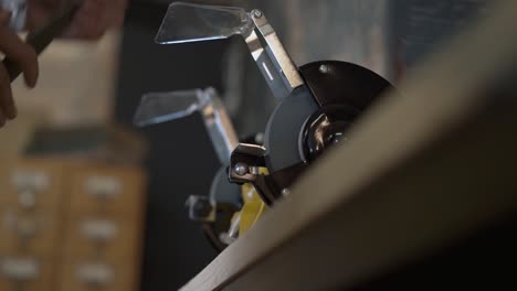 electric sharpener and blade close up, hands cutting knife