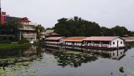 Una-Vista-Increíble-De-Muchas-Casas-De-Madera-Flotando-En-El-Río-Con-Montaña-En-Kanchanaburi,-Tailandia