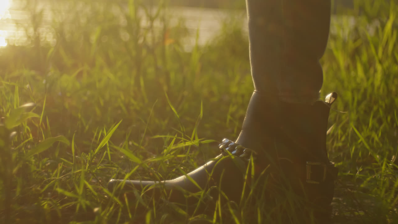 Woman Walking Through Grass at Sunset