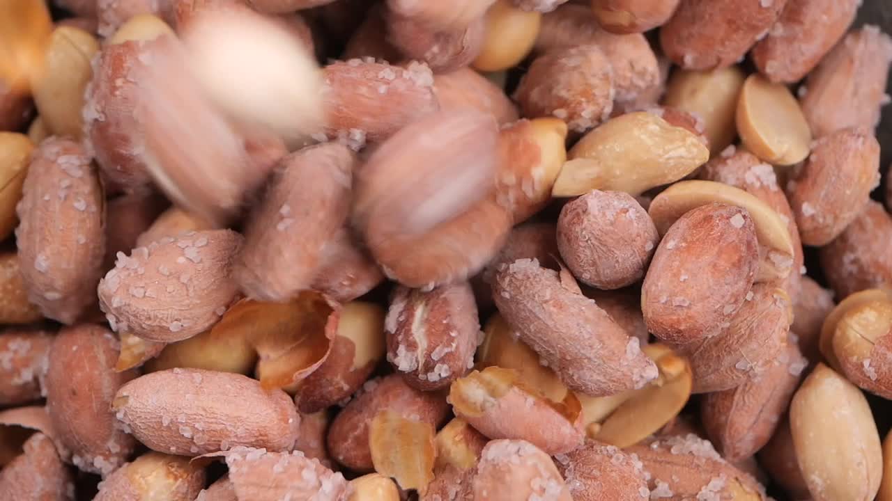 Nærbillede af saltede ristede jordnødder der falder