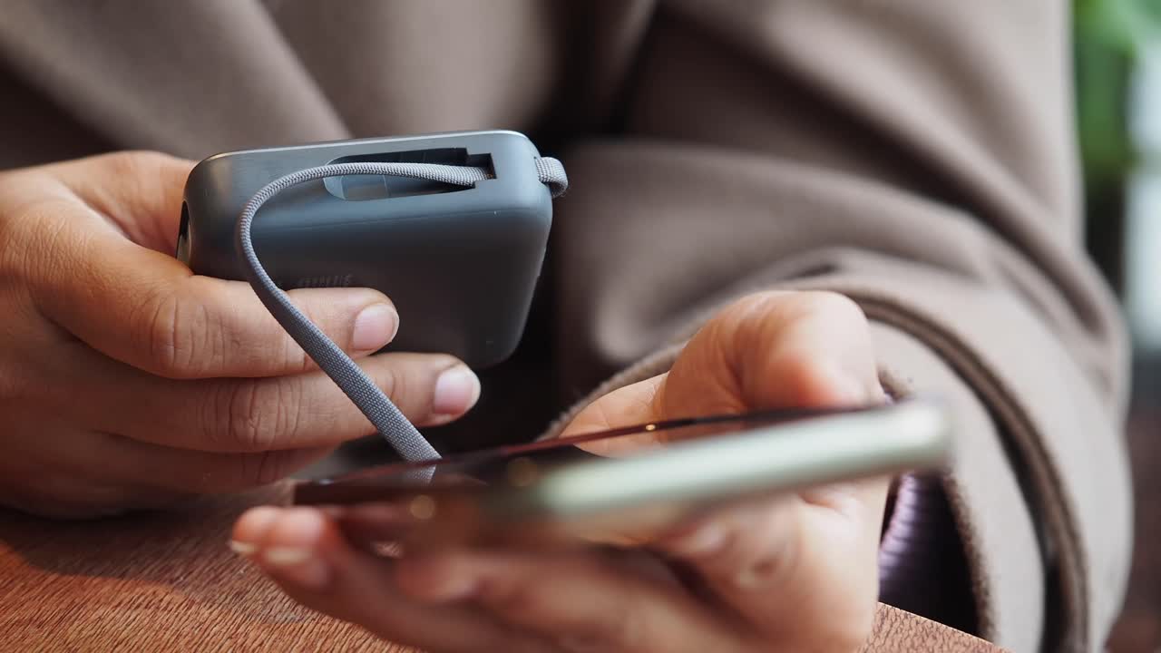 Person holding a power bank and a mobile phone