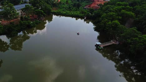 Beautiful-aerial-of-a-distant-pedalo-in-a-large-lake-in-Abuja,-Nigeria