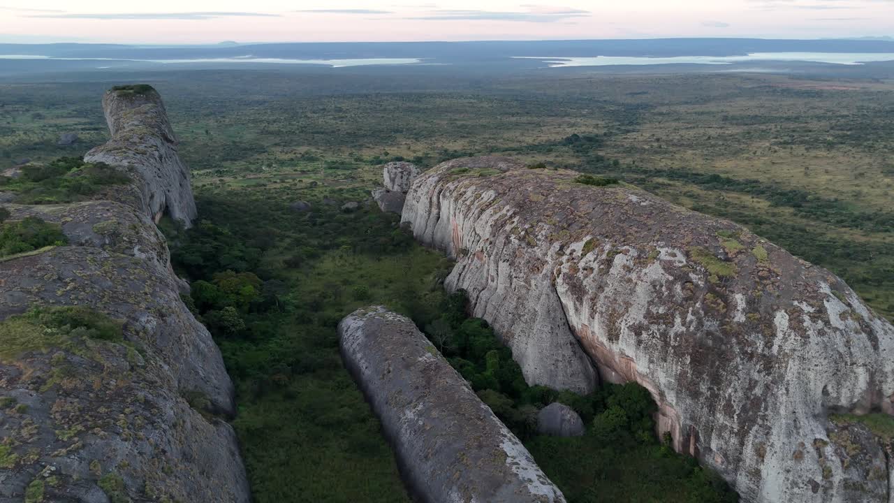 Ripresa aerea con drone all'interno delle profonde fessure di pietra di Pedras Negras de Pungo Andongo nella provincia di Malanje, Angola, Africa, che mostra enormi scogliere verticali al tramonto