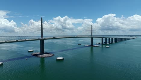 drone video flying toward sunshine skyway bridge on a sunny day with beautify puffy white clouds in the distance