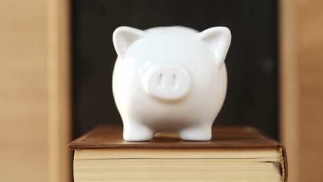 close-up of books stack with piggy bank