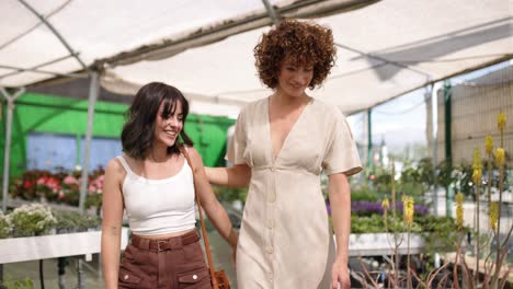 happy women enjoying time together in greenhouse plant nursery