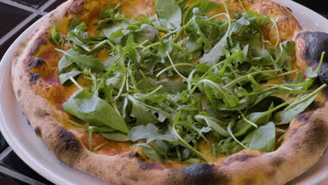 close up of pizza with arugula and pizza margarita on white plates at restaurant