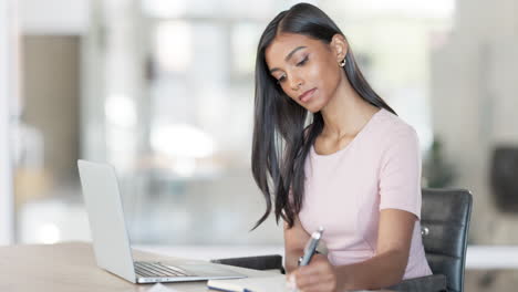 Young-business-woman-using-a-laptop-to-work-online
