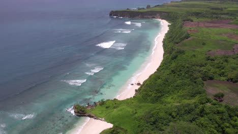 Mbawana-Beach-at-Sumba-with-small-waves-during-cloudy-day,-aerial-shot