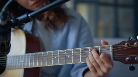 Attractive-girl-recording-sound-of-guitar-with-condenser-microphone