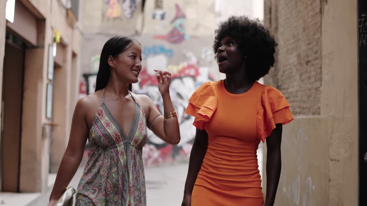 Two women walking and talking on a city street