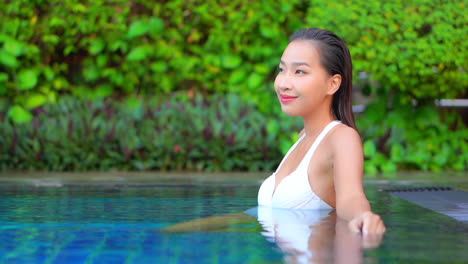 close-up of a beautiful woman sitting in the shallow water of a swimming pool