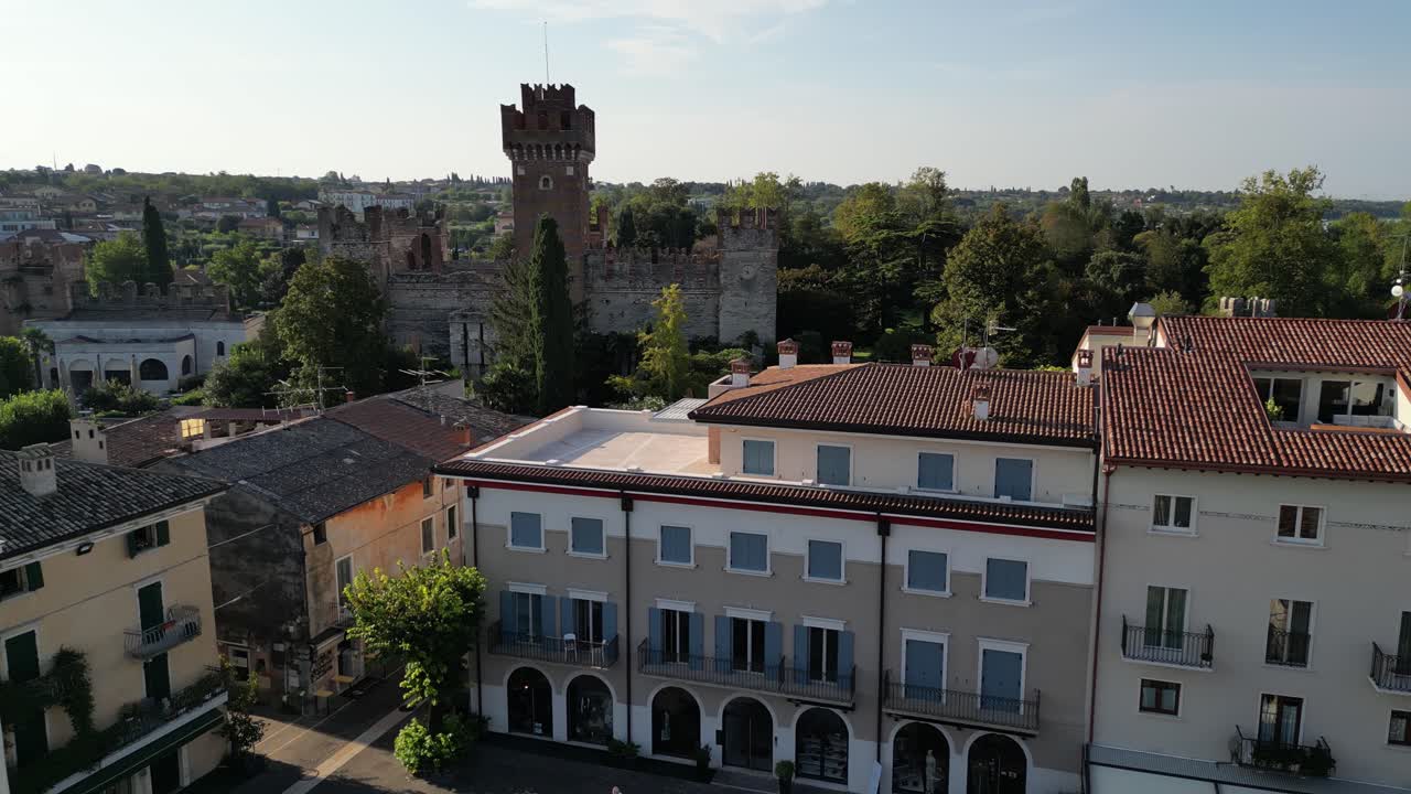 país pobre con hermosos edificios con una torre en primer plano volando a su alrededor para revelar el castillo y el romanticismo buscando arquitecturas un montón de ventanas españolas y jardín en el techo cubierto de naturaleza