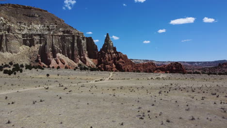 A-desert-crossed-by-a-road,-bordered-by-high-cliffs,-in-broad-daylight,-bird's-eye-view-fast-motion-of-Kodachrome-State-Park-Utah