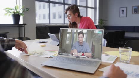 hombre de negocios caucásico en una videollamada con un colega caucásico en la pantalla