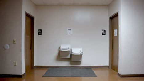 static shot of toilets entrance with double sink