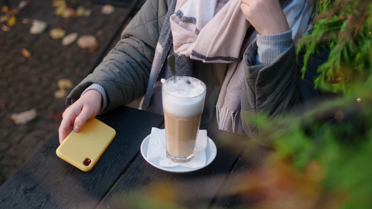 Woman enjoying a latte outdoors in autumn