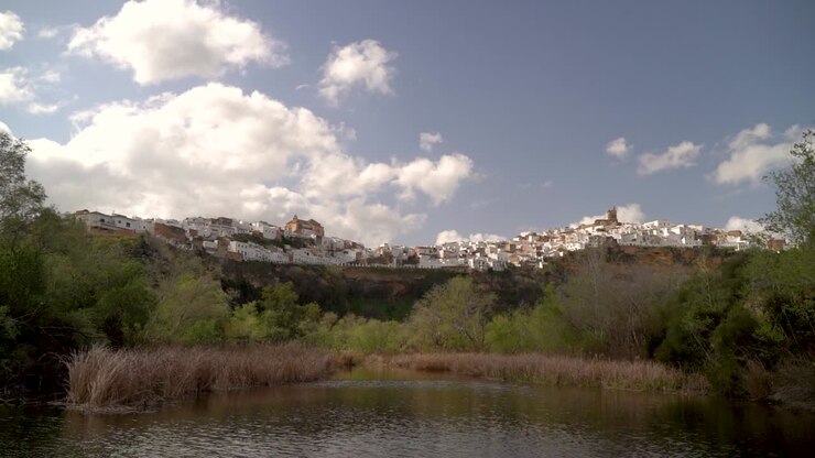 Panoramica su un piccolo stagno con vista su un villaggio spagnolo imbiancato su una collina