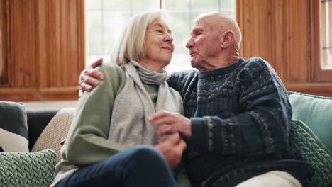 Hug,-kiss-and-senior-couple-relax-on-a-sofa