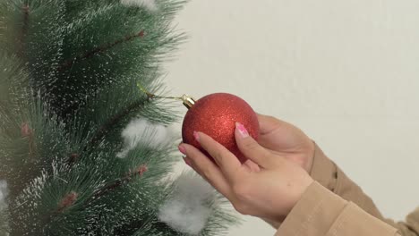 La-Mano-De-Las-Niñas-Cuelga-La-Decoración-De-Adornos-Rojos-En-El-árbol-De-Navidad-De-Cerca.