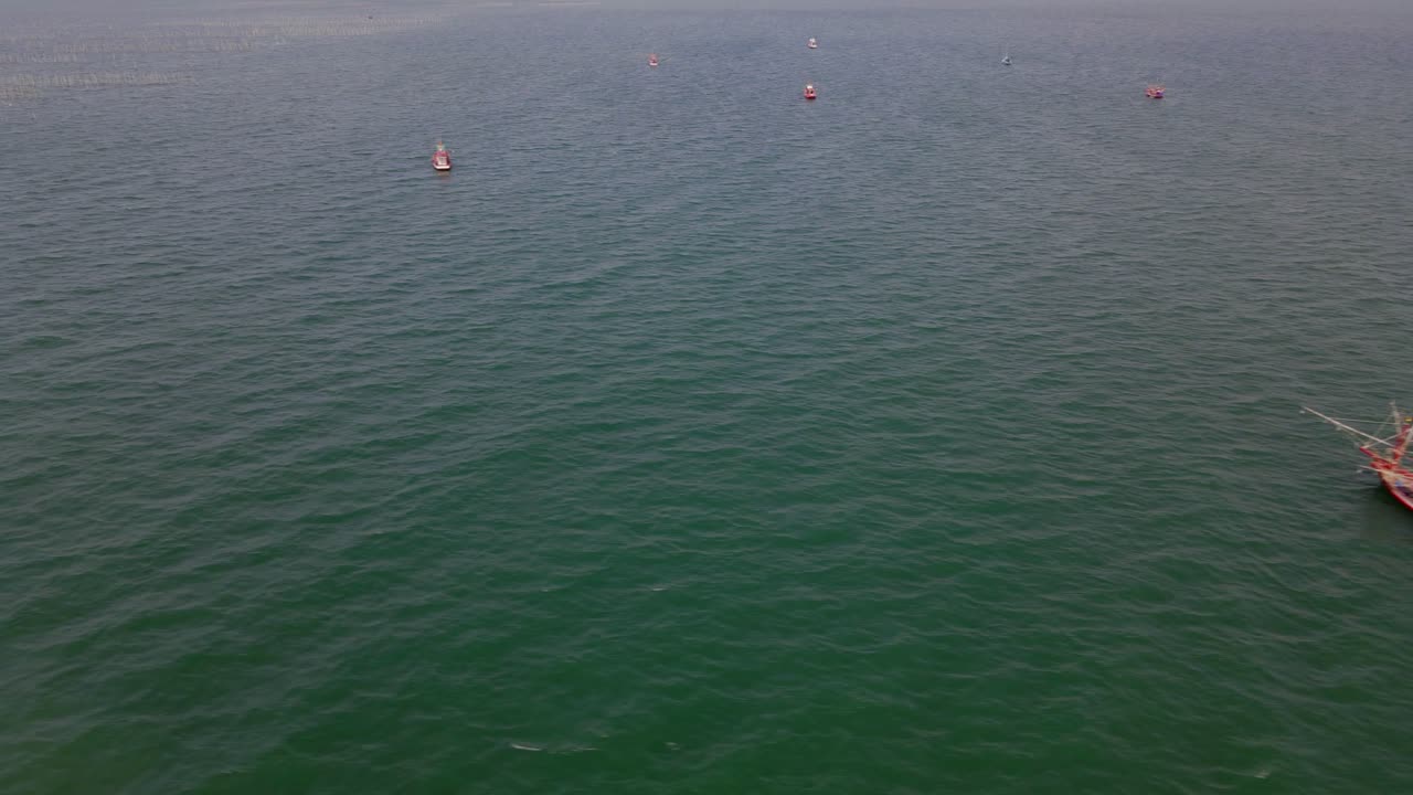 왼쪽으로 미끄러지는 항공 영상은 태국 촌부리의 바다 한가운데에서 볼 수 있는 프레임 상단에 큰 어선 등을 보여줍니다.