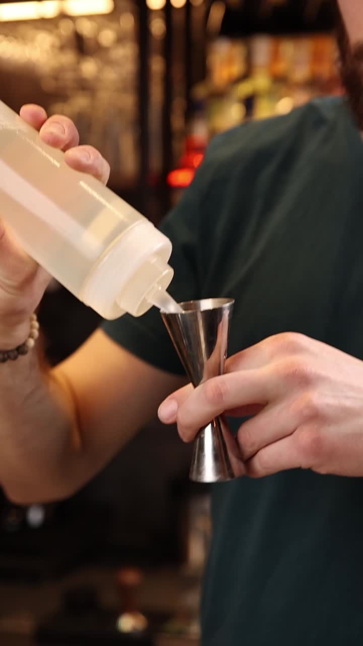 Il barista versa il liquido nel jigger