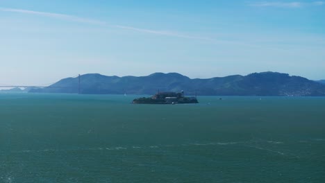 Distant-drone-shot-of-Alcatraz-Island-during-the-day-with-many-boats