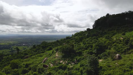 Phnom-Kulen,-Kambodschas-üppige-Grüne-Landschaft,-Tief-über-Einem-Hügel-Mit-Sandsteinfelsen-Und-Bewölkter-Skyline-Während-Der-Regenzeit